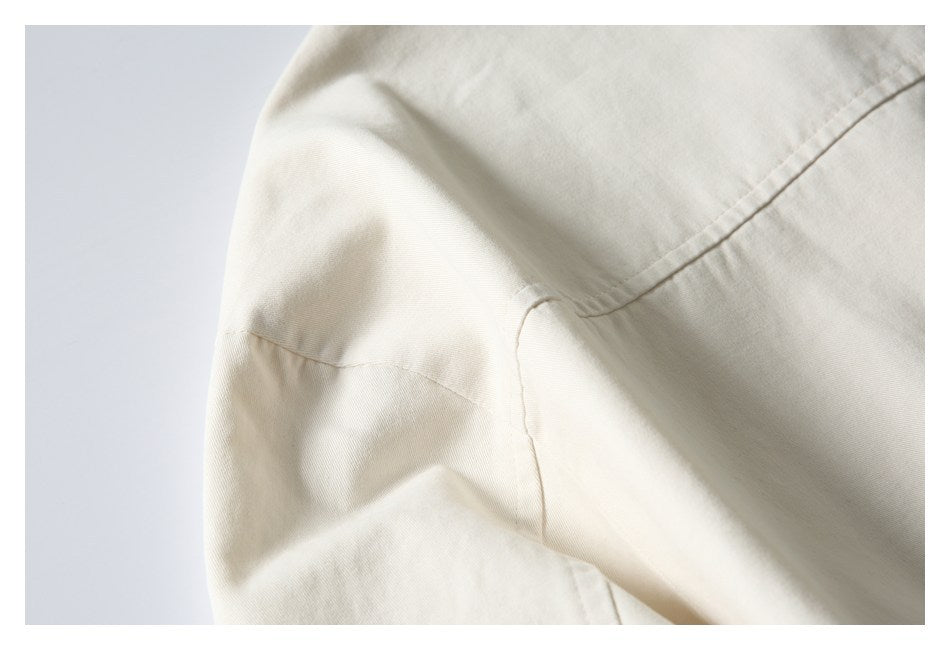 Close-up of stitched seams joining panels of an ivory garment.