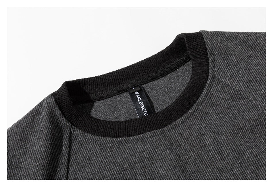 Close-up of a charcoal sweatshirt's black ribbed crew neck and inner neck label.