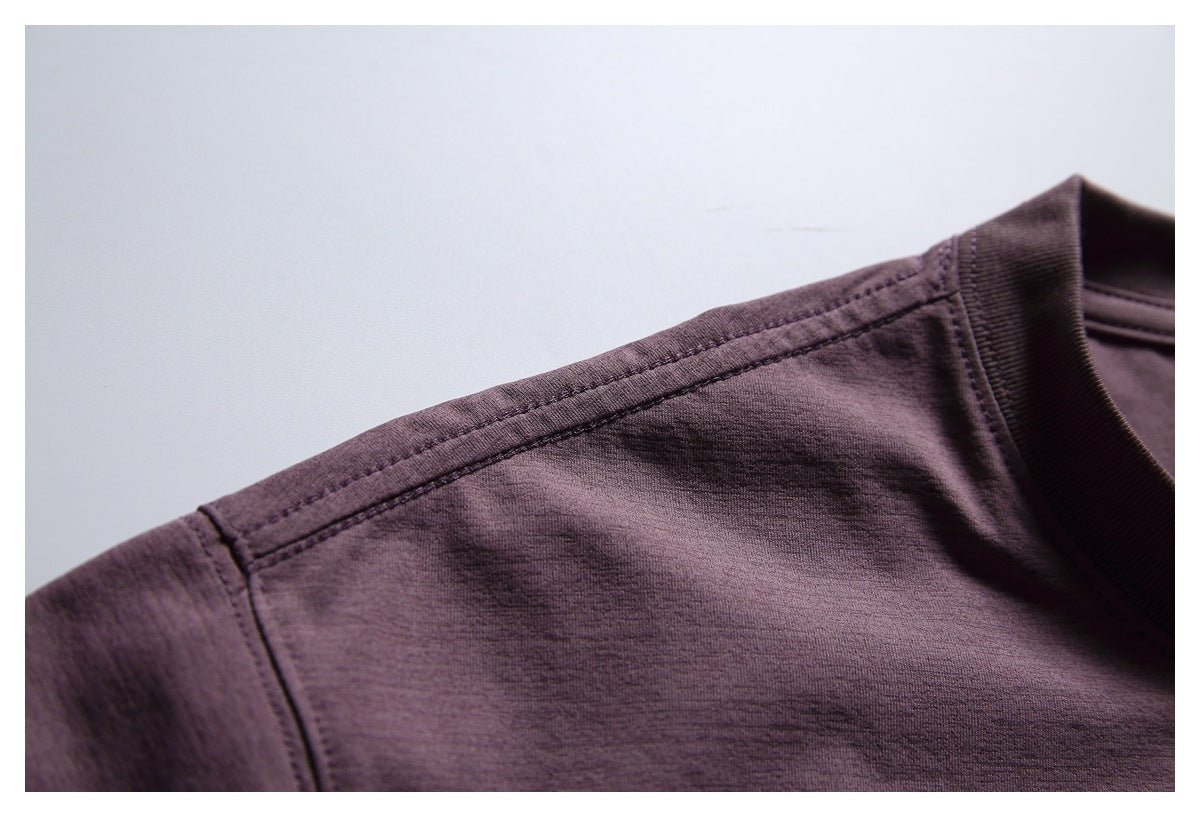 Close-up of the plum T-shirt's shoulder seam and ribbed crew neckline.
