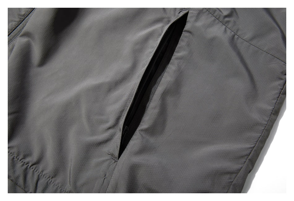 Close-up of a dark gray garment with a long black zippered pocket.