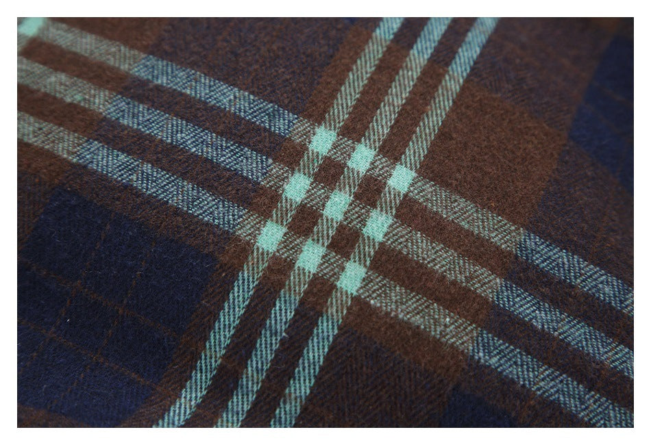 Close-up of brown and navy plaid fabric crossed by pale aqua stripes.