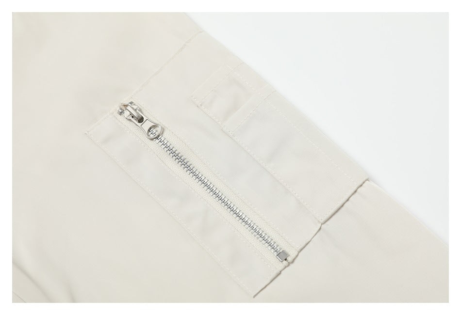 Close-up of a silver zipper and stitched placket detail on the ivory jacket.