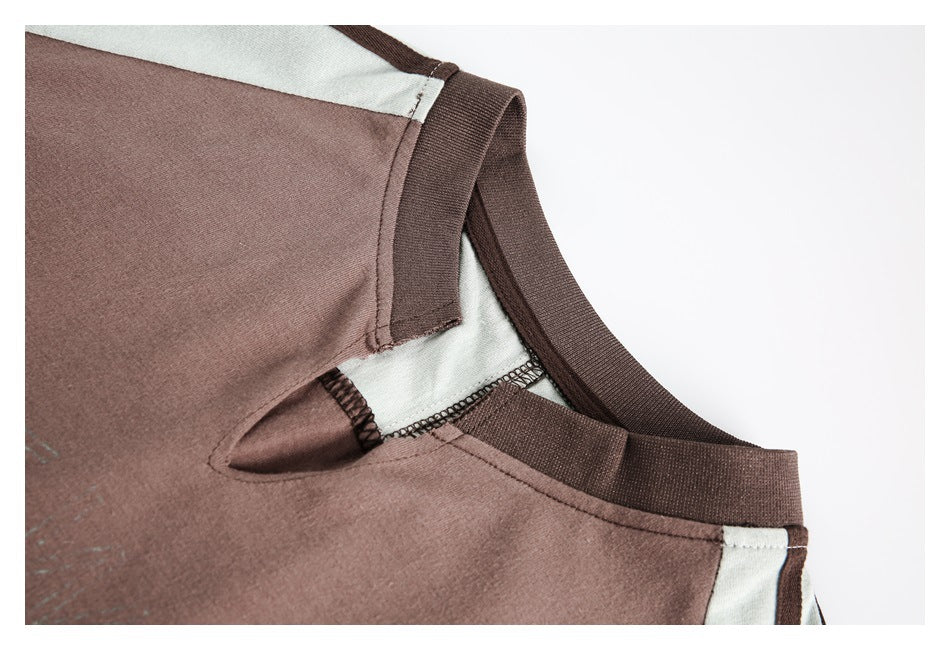 Close-up of a dusty rose garment neckline and shoulder with dark brown trim and pale contrast panels.