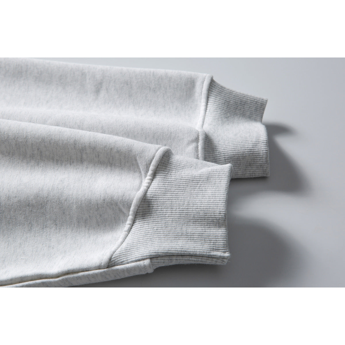 Close-up of the light gray jacket's long sleeves and ribbed cuffs.