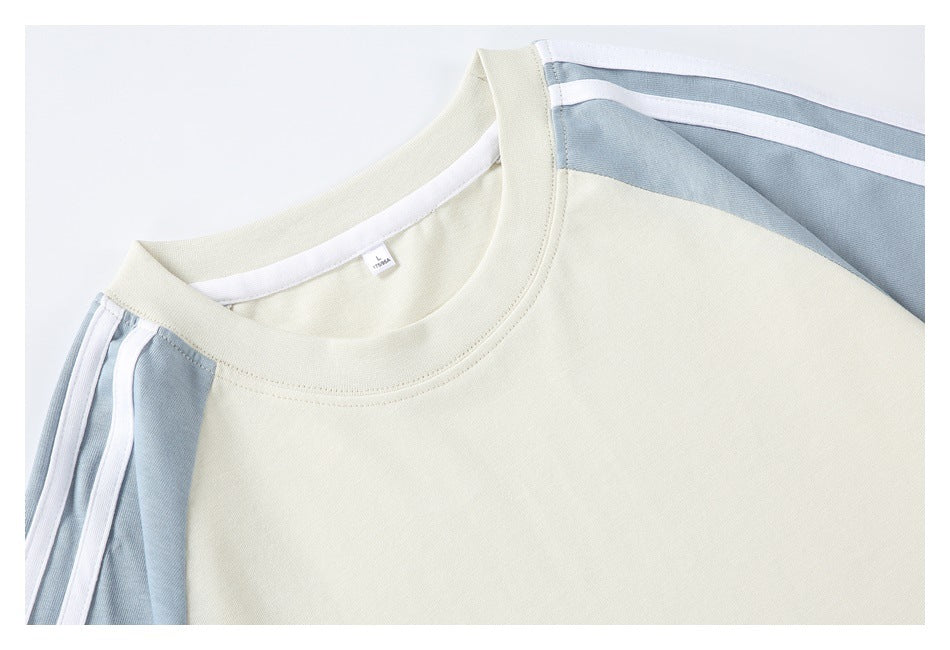 Close-up of an ivory T-shirt neckline and pale blue shoulder panels with white stripes.