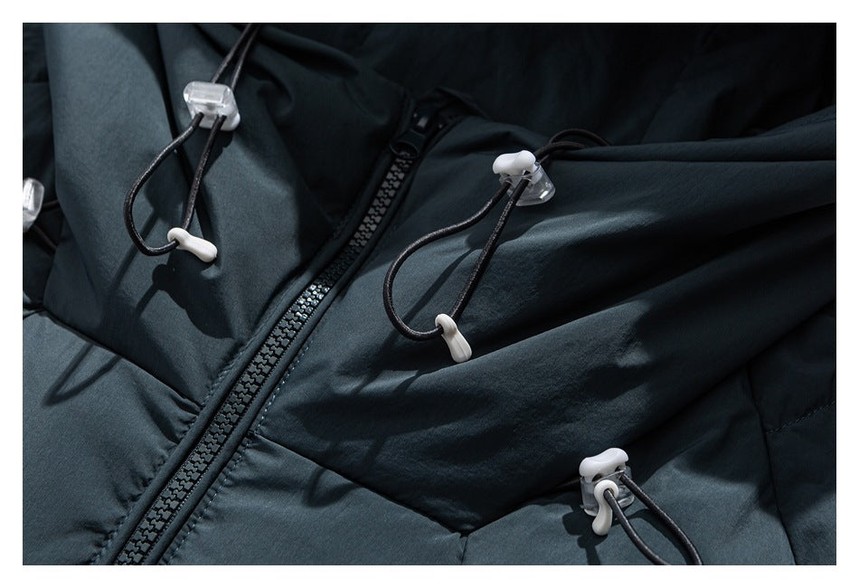 Close-up of the dark blue-gray jacket's front zipper and adjustable black drawcords with white toggles.