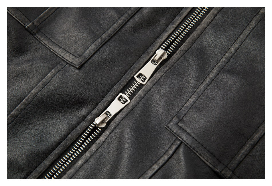 Close-up of a black jacket with a diagonal silver zipper featuring two pulls and stitched panel pockets.