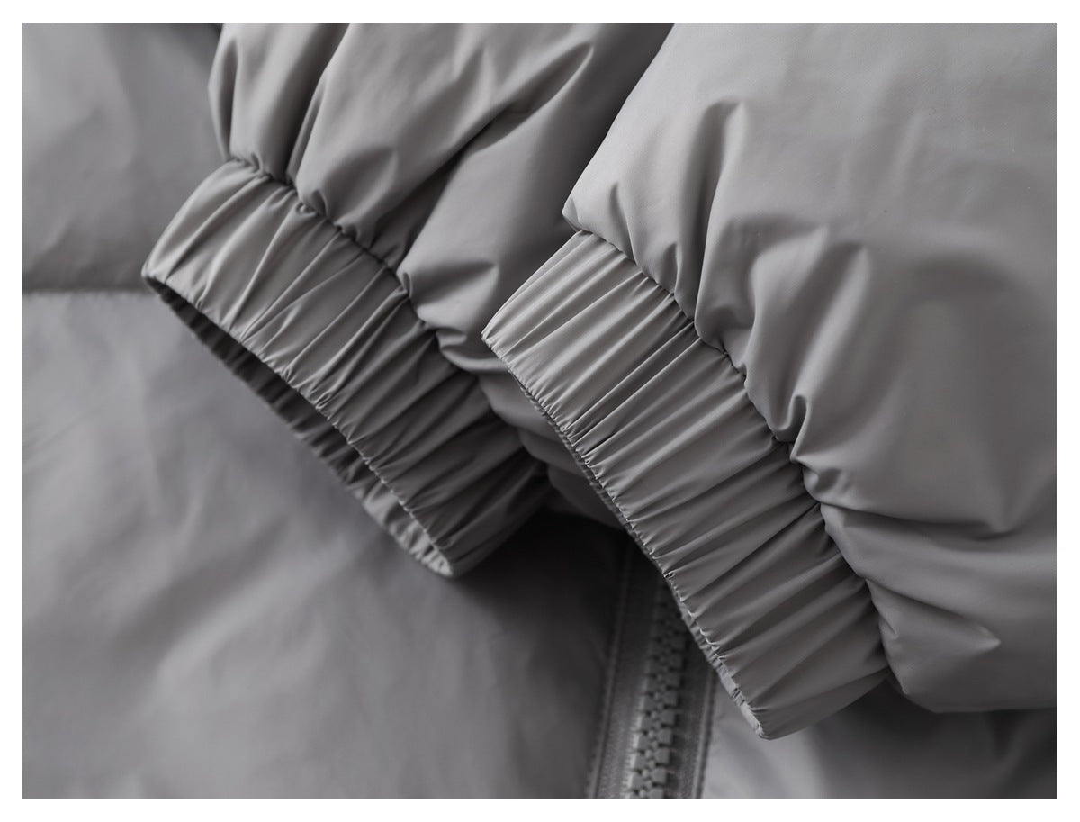 Close-up of a gray jacket's gathered elastic cuffs and front zipper.