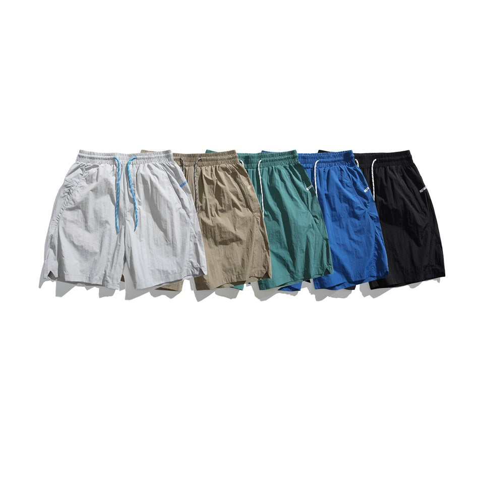 Six pairs of elastic-waist shorts shown together in light gray, beige, teal, blue, and black.