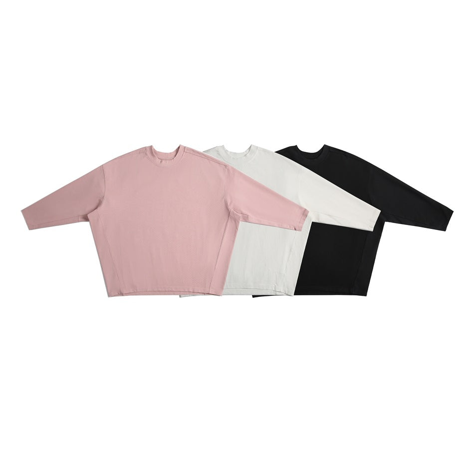 Three oversized crew-neck tops with wide sleeves shown together in dusty pink, off-white, and black.