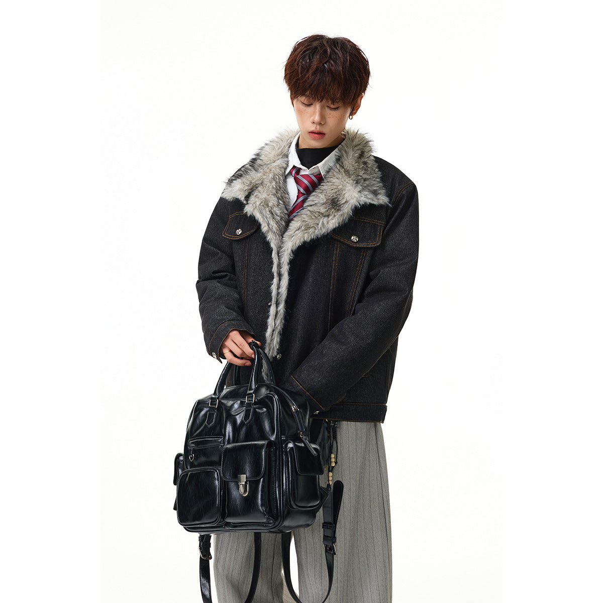 Model wearing a charcoal denim jacket with a wide gray faux-fur collar, holding a black bag.