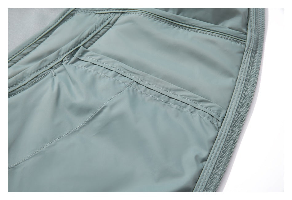Close-up of a stitched pocket and zipper edge on the pale blue-gray garment lining.
