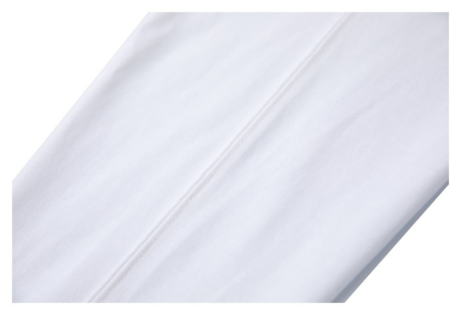 Close-up of white garment fabric and a diagonal stitched seam.