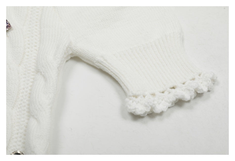 Close-up of a short sleeve on the white knit top, showing ribbed fabric and a scalloped edge.