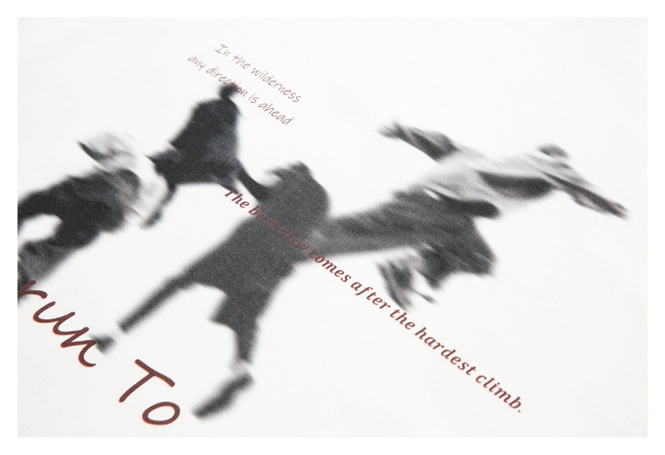 Close-up of a dark blurred-figure graphic with reddish English text on off-white fabric.