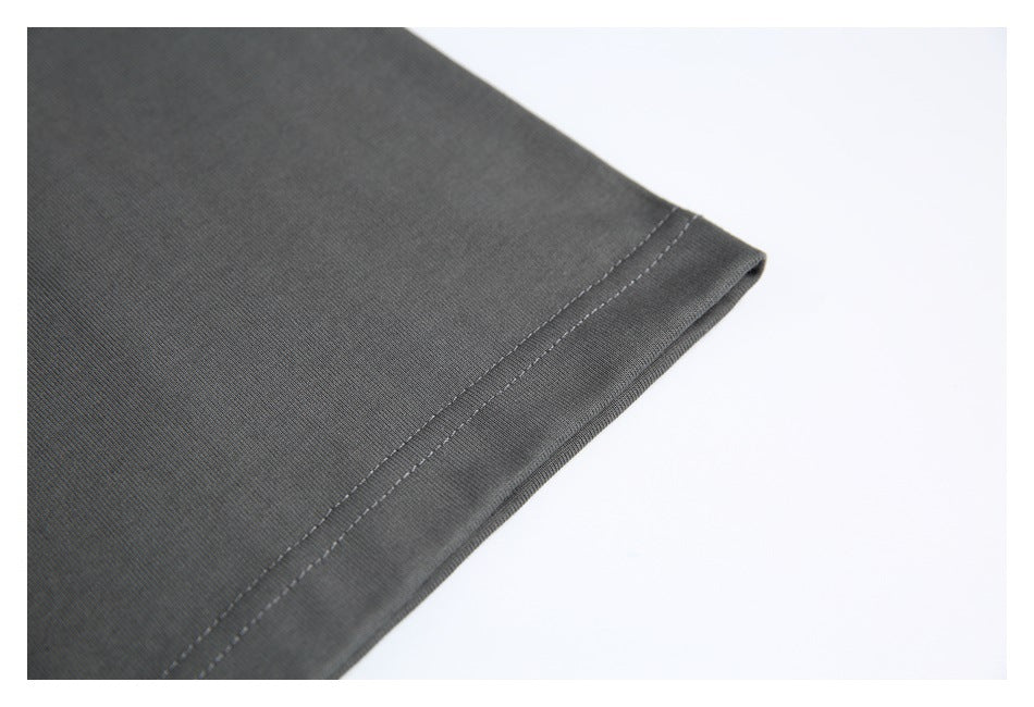 Close-up of the charcoal T-shirt's stitched sleeve hem against a white background.