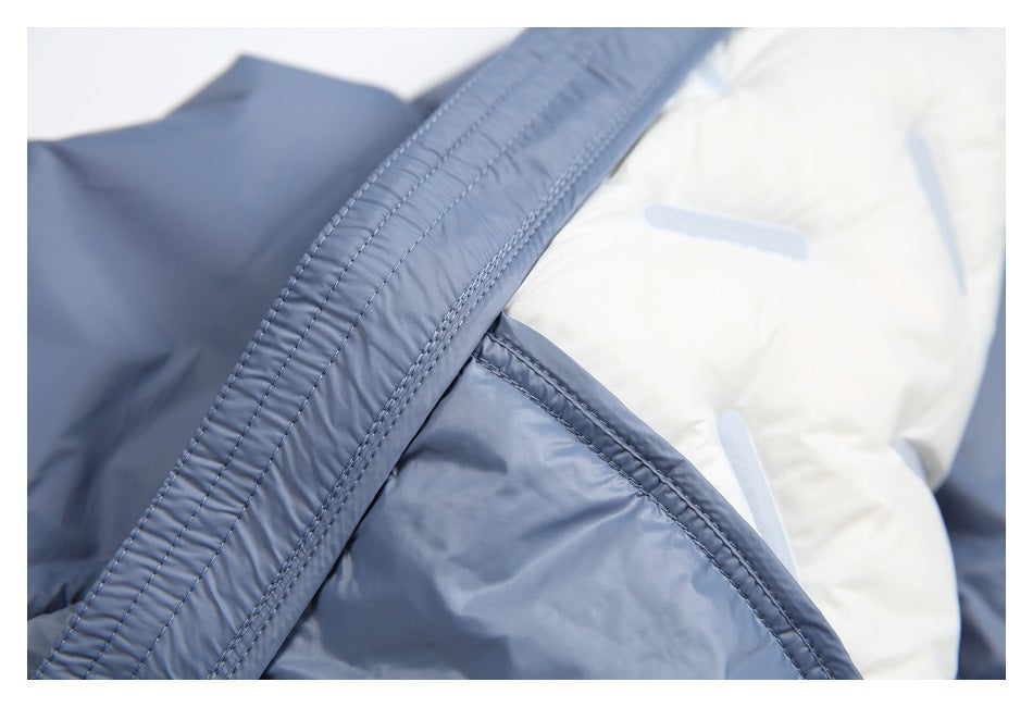Close-up of the blue-gray jacket's stitched edge and pale lining with light-blue tabs.