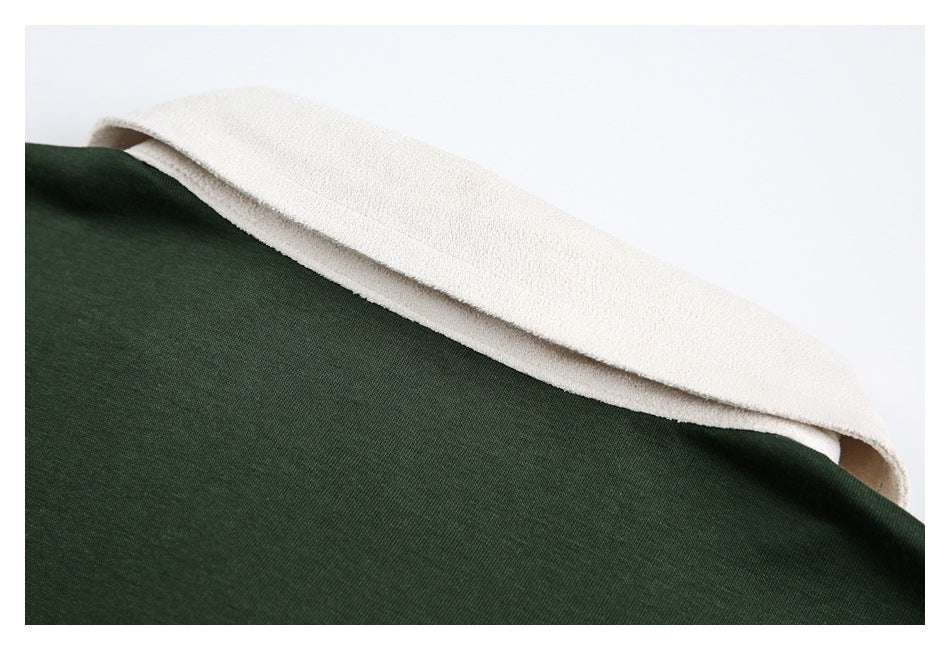 Close-up of dark green garment edge beside a soft-looking cream-colored inner layer.