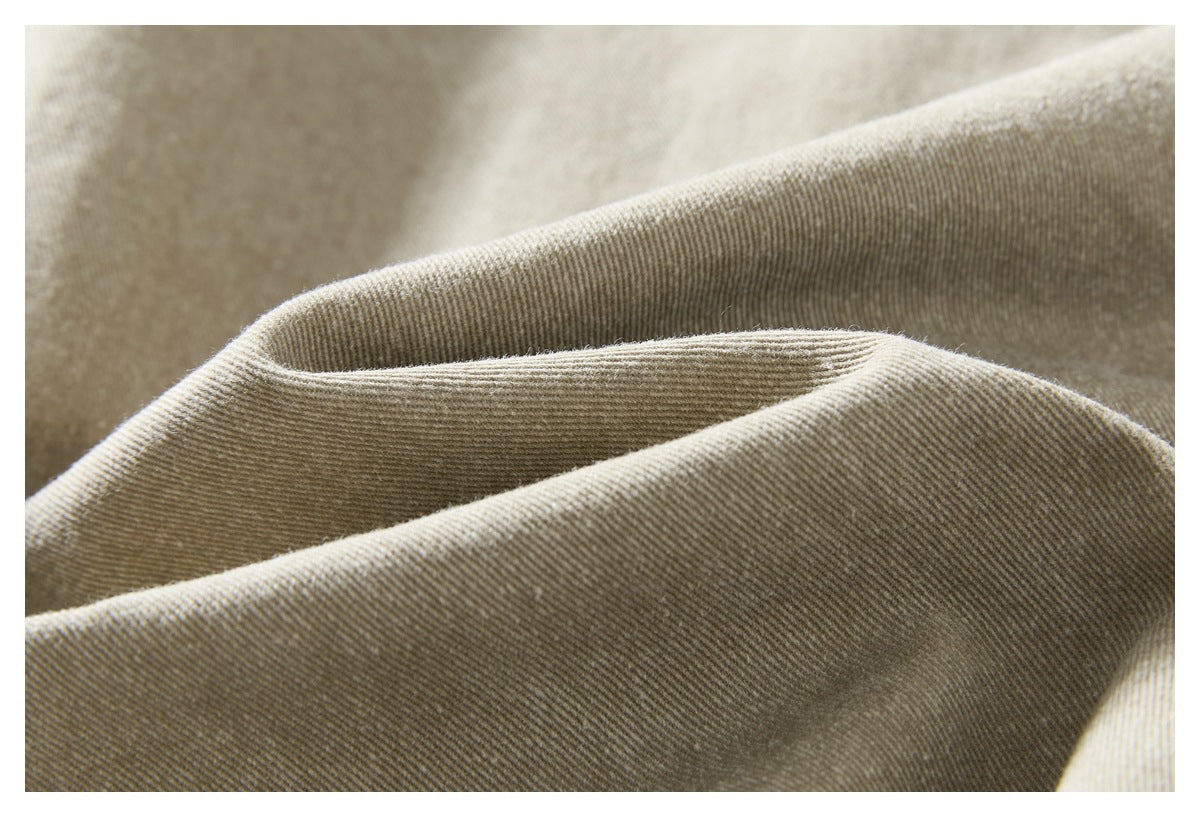 Close-up of beige fabric folded to show its diagonal twill texture.