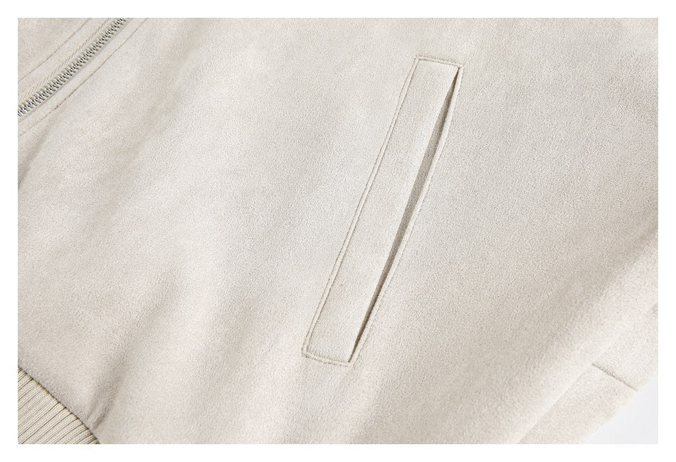 Close-up of a light beige jacket showing a narrow welt pocket and part of the front zipper.