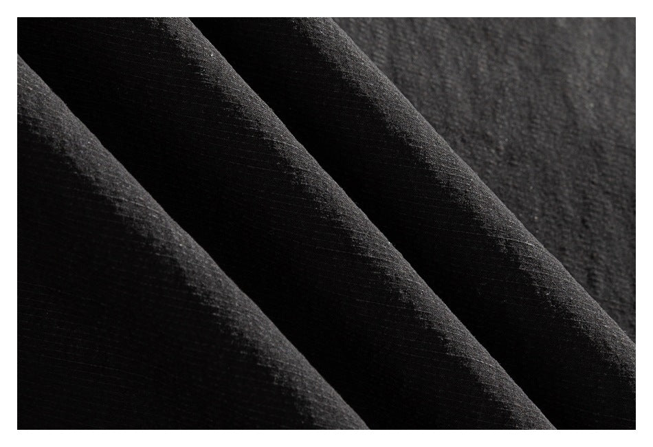 Close-up of black fabric showing a fine, subtle grid-like texture.
