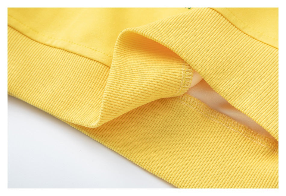 Close-up of the yellow sweatshirt's ribbed bottom band and stitched seam.