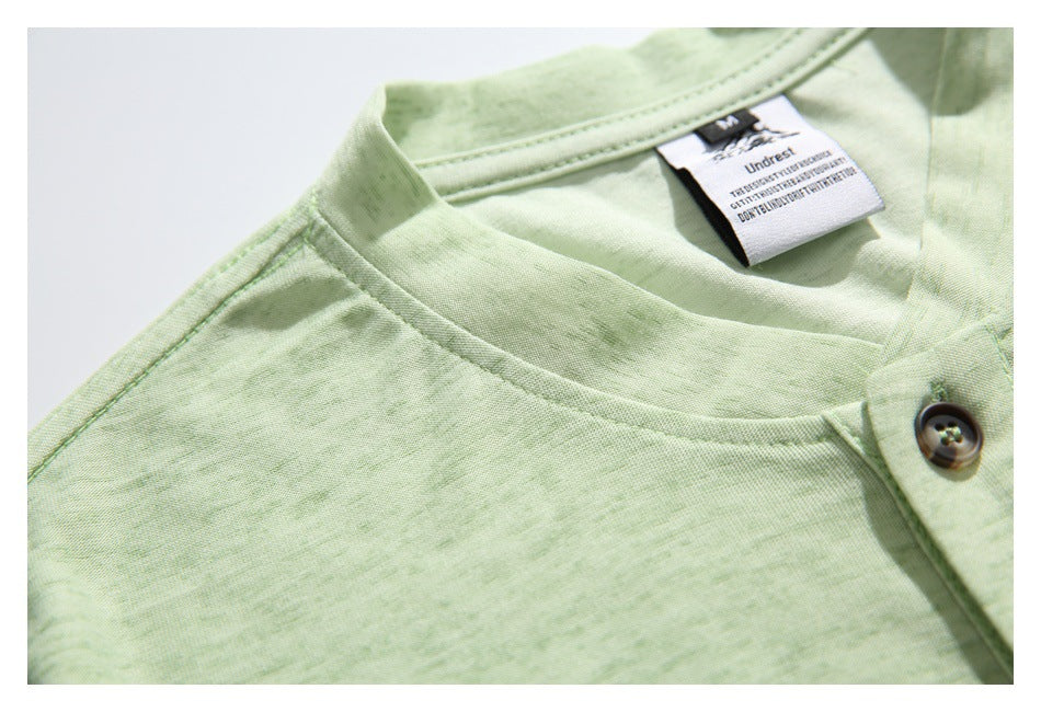 Close-up of the pale green shirt's neckline, shoulder seam, and sewn neck label.