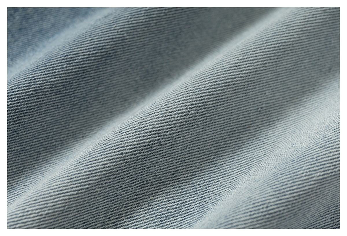 Macro view of the diagonal twill texture and faded blue tones of denim fabric.