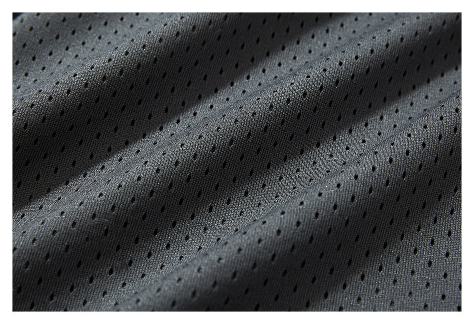 Extreme close-up of charcoal fabric with a repeating pattern of small ventilation holes.