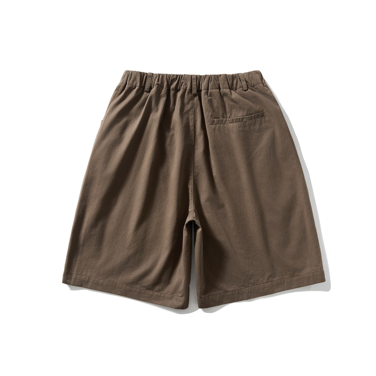 Back view of brown wide-leg shorts with an elasticated waistband, belt loops, and one welt pocket.