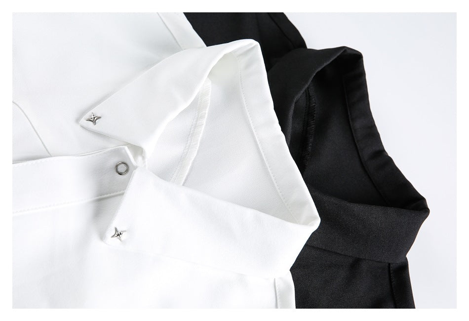 Close-up of white and black shirt collars with small silver star-shaped hardware and a metal eyelet.