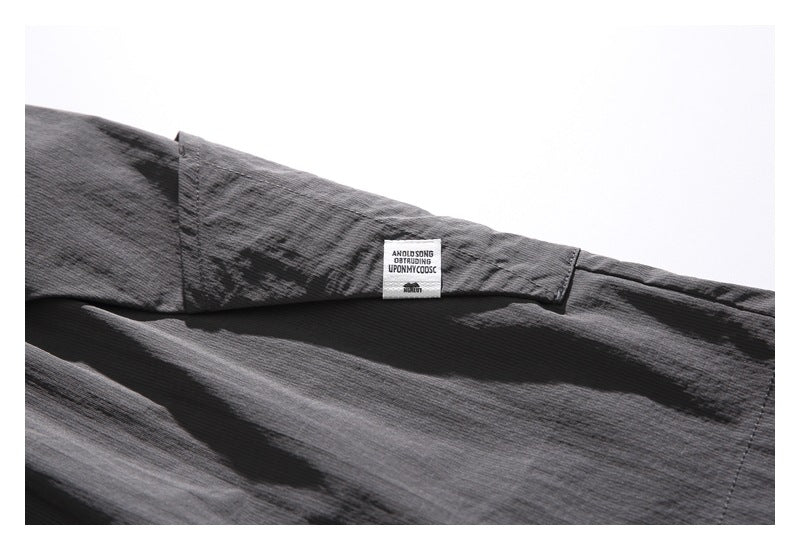 Close-up of a small white sewn label on the charcoal shorts.