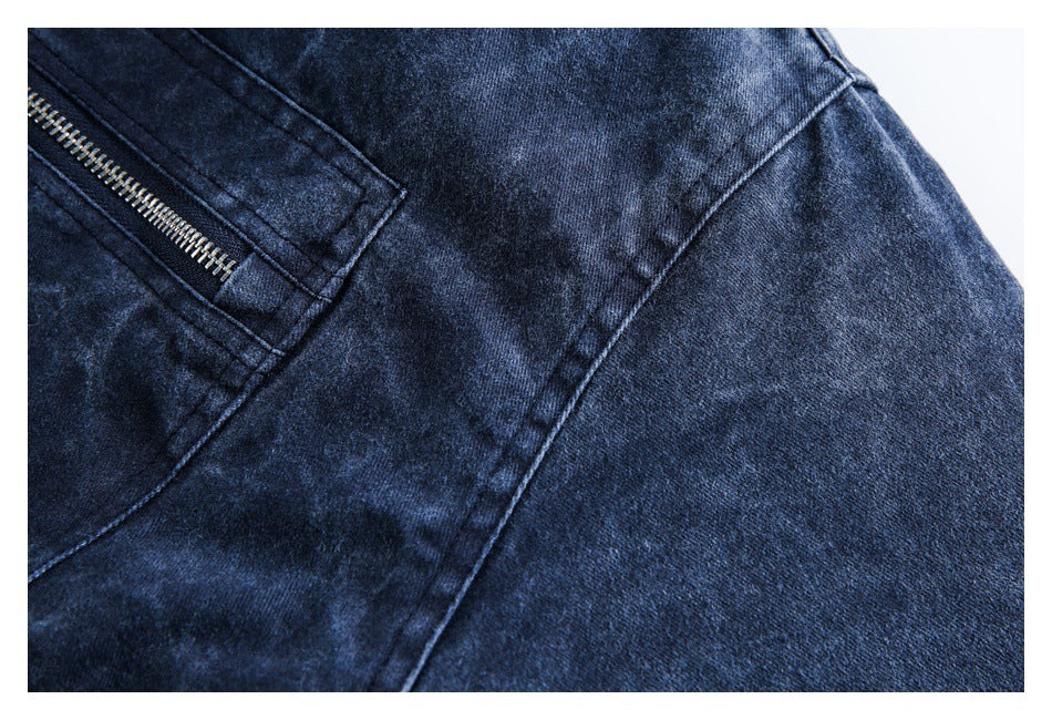 Close-up showing the dark blue jacket fabric, stitching, and edge of a zippered pocket.