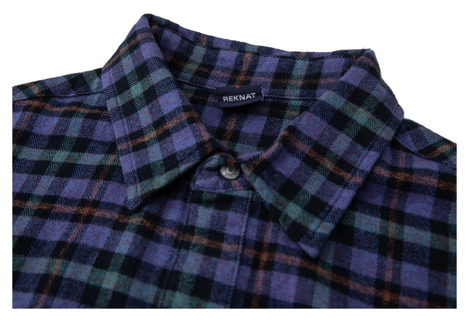 Close-up of the pointed collar, top button, and sewn-in brand label on a purple and black plaid shirt.