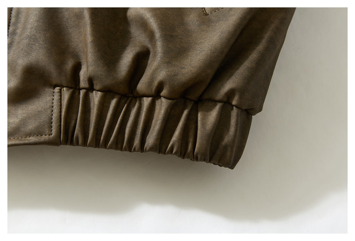 Close-up of a brown jacket's gathered elastic hem and stitched panel.