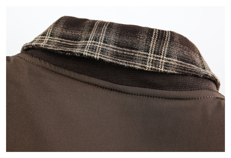 Close-up of a brown jacket collar with brown plaid fabric and a dark ribbed band.