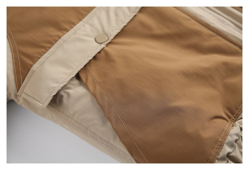 Close-up of a cream snap-fastening tab beside a tan panel on the jacket.