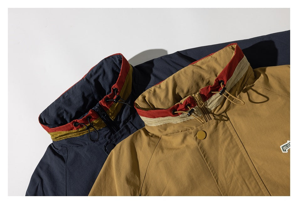 Close-up of tan and navy jackets with red-trimmed collars, drawcords, and front closures.