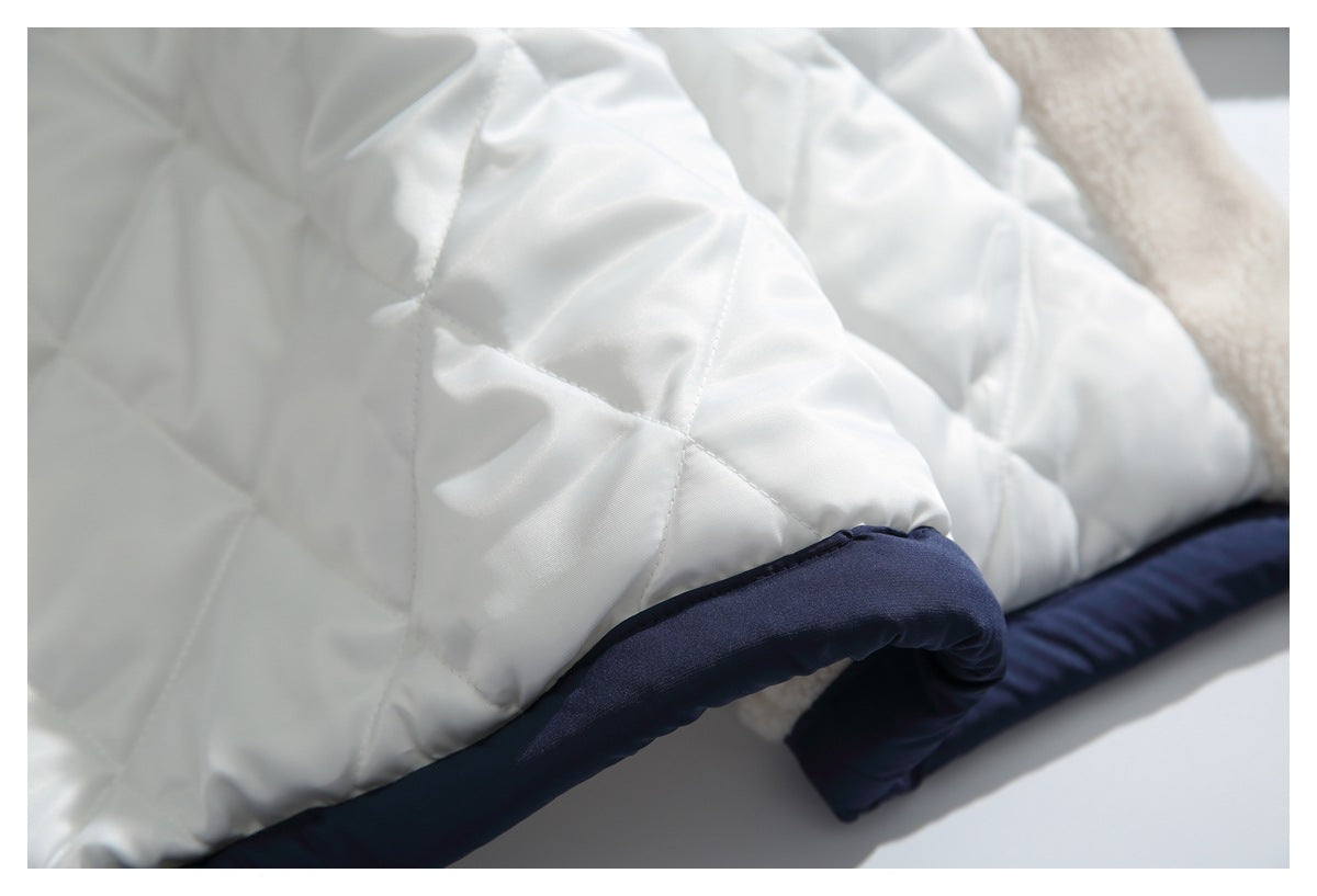 Close-up of white diamond-quilted jacket lining with navy edging and a cream fleece section.