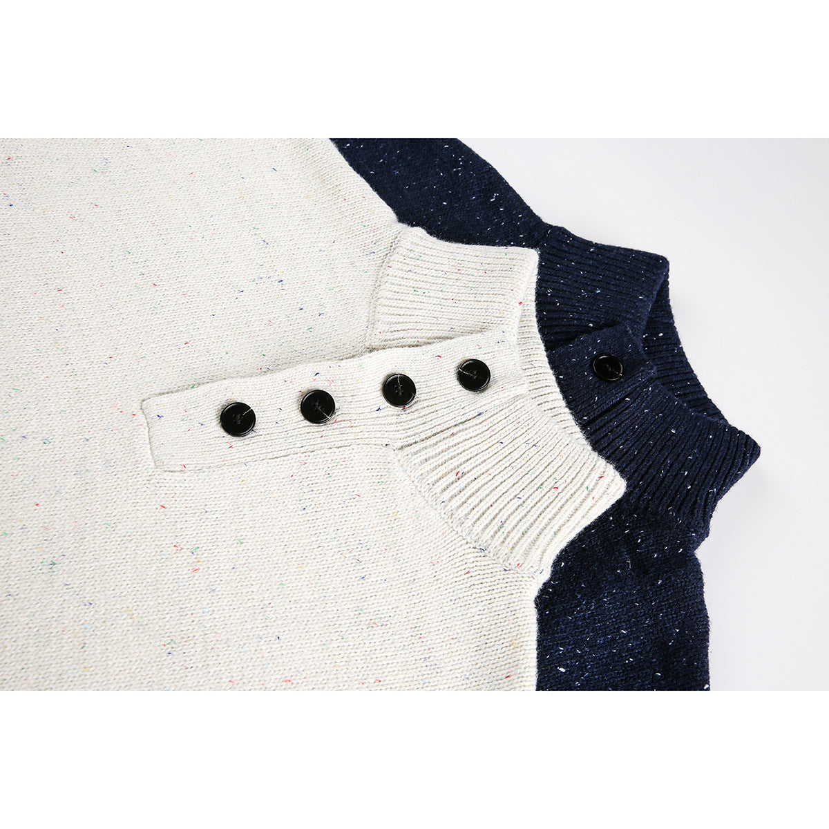 Close-up of cream and navy speckled knit sweaters showing ribbed stand collars and black buttons.