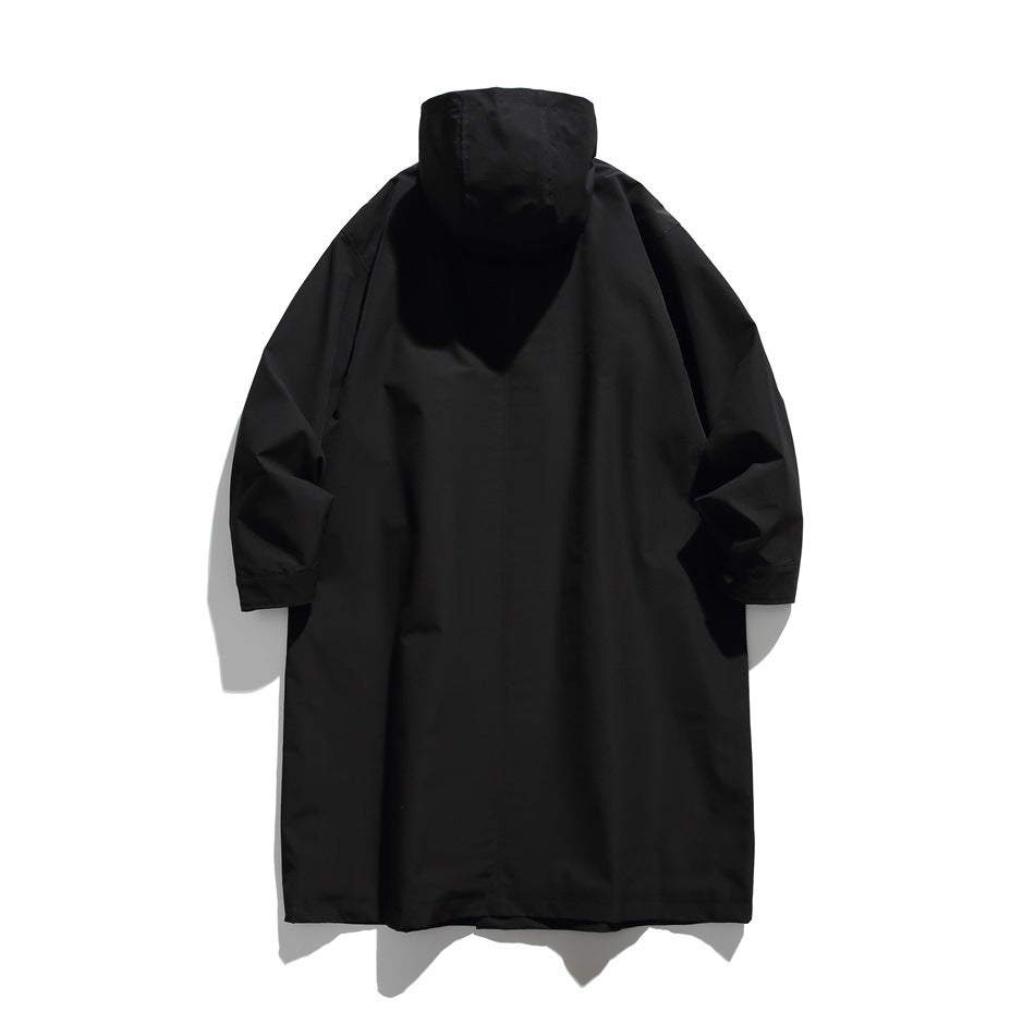 Back view of black long hooded coat with a center back seam, flat lay on a light background