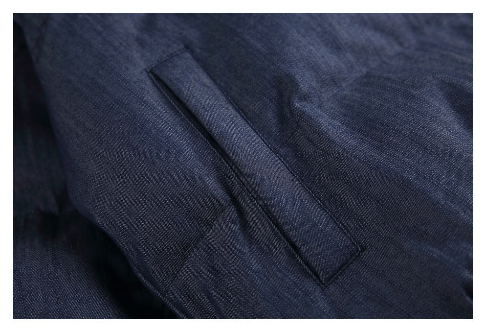 Close-up of a slanted welt pocket on dark blue jacket fabric.