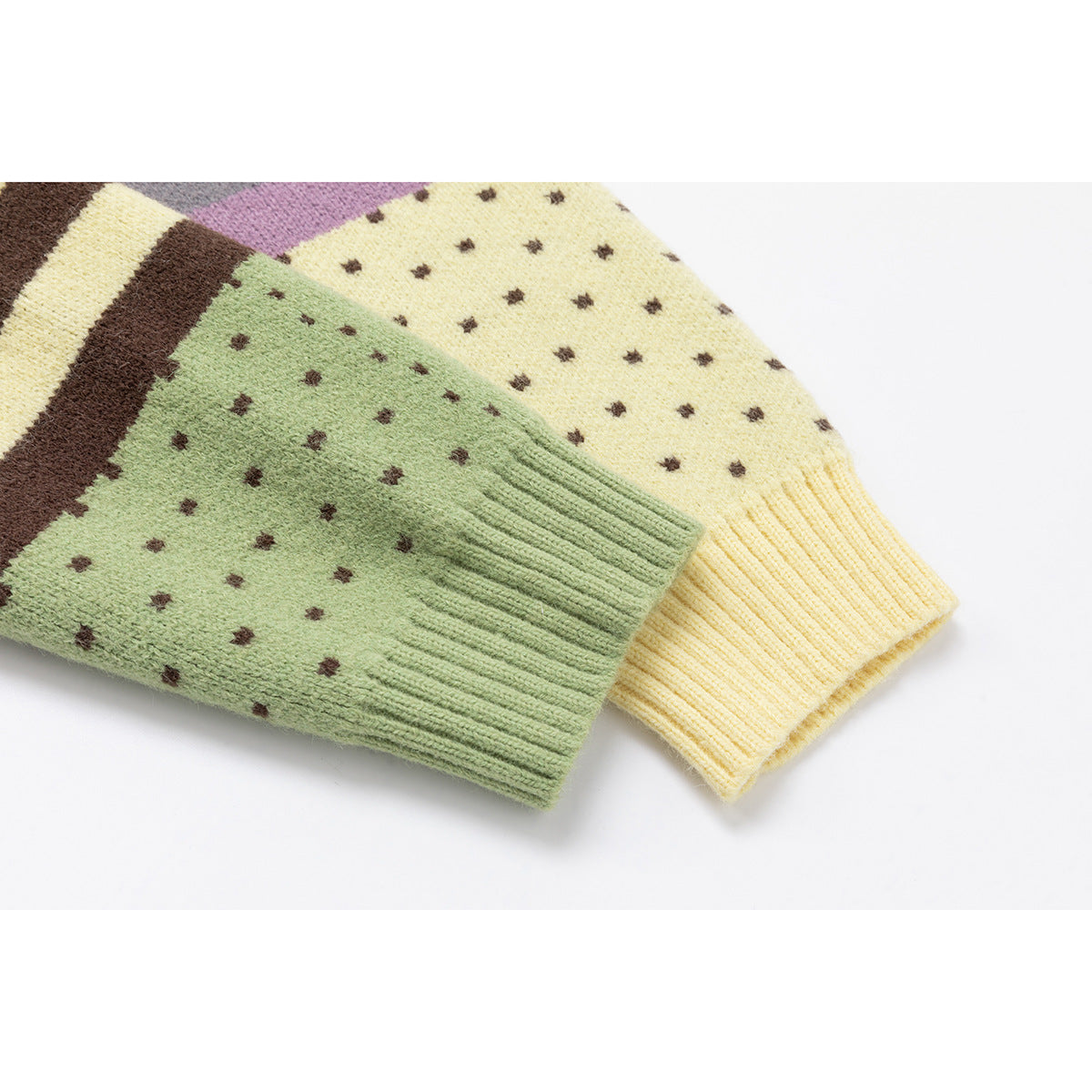 Close-up of green and pale yellow cardigan sleeves with ribbed cuffs and small brown dots.