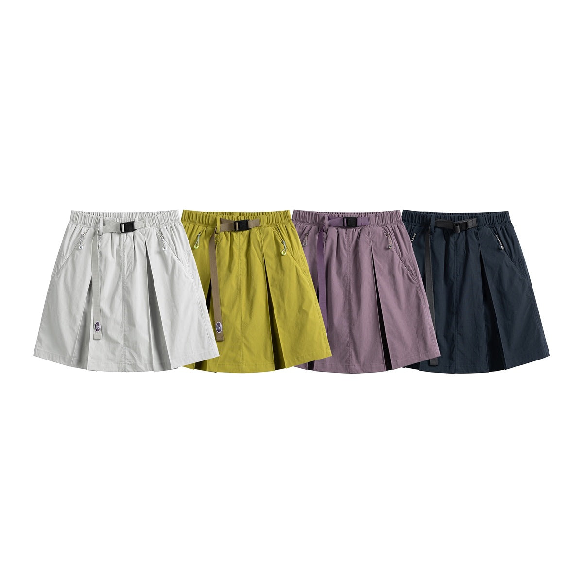 Four pleated tennis skirts shown together in light gray, mustard yellow, mauve, and dark navy.