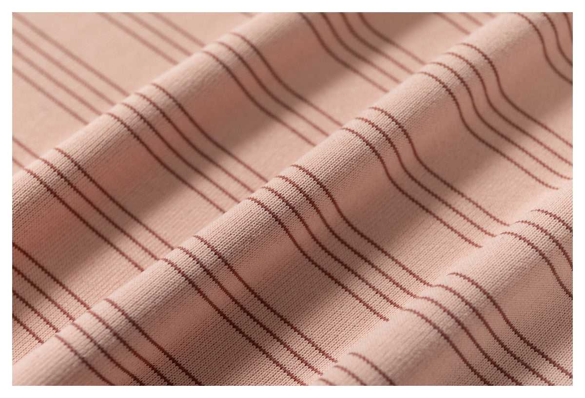 Close-up of pink striped fabric draped into folds, showing its fine knit texture.