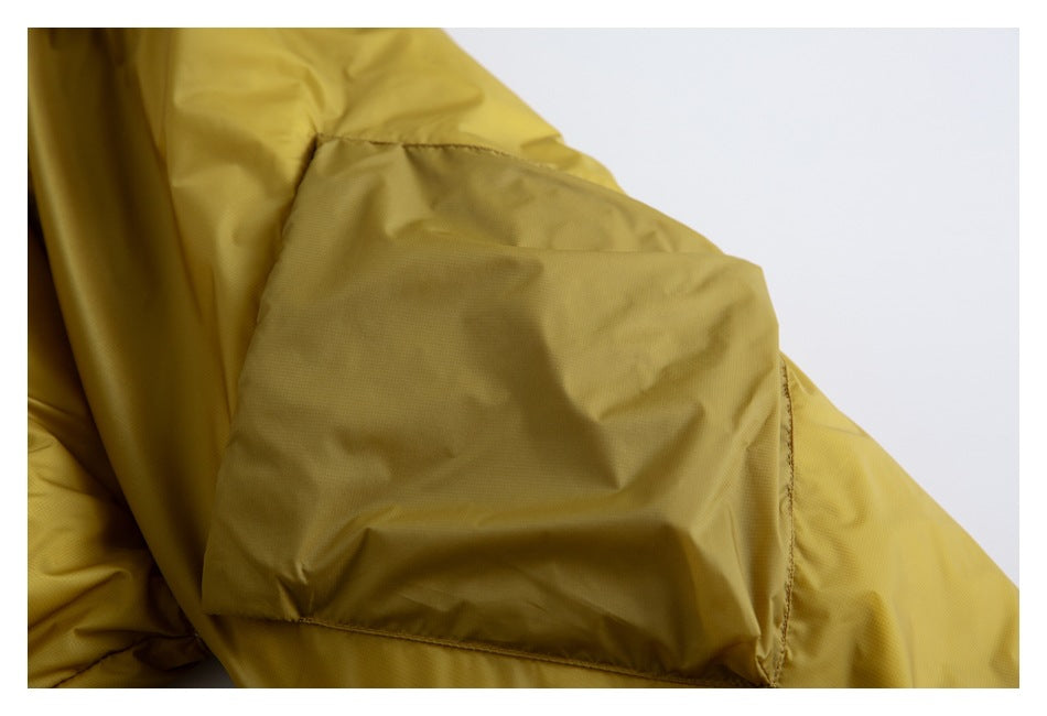 Close-up of mustard-yellow garment fabric with a stitched panel and seam.
