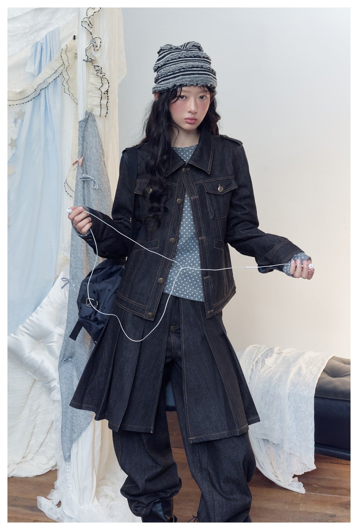 Full-length model in a dark indigo denim jacket with flap pockets and long split panels, wide-leg jeans and a gray polka-dot