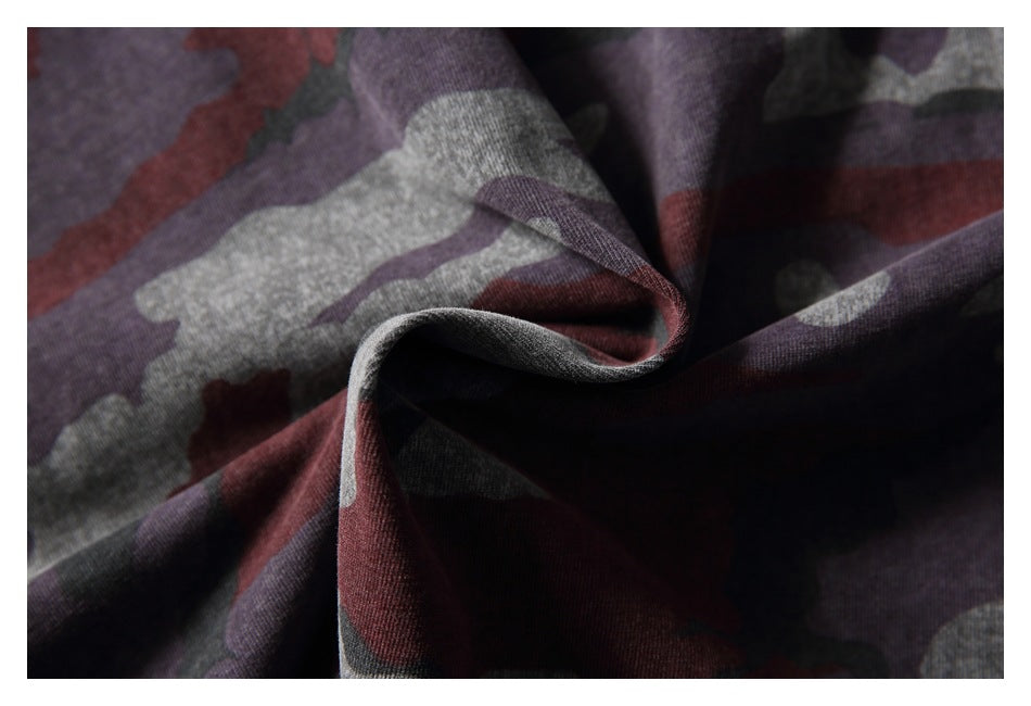 Close-up of maroon, gray, and dark camouflage fabric gathered into soft folds.