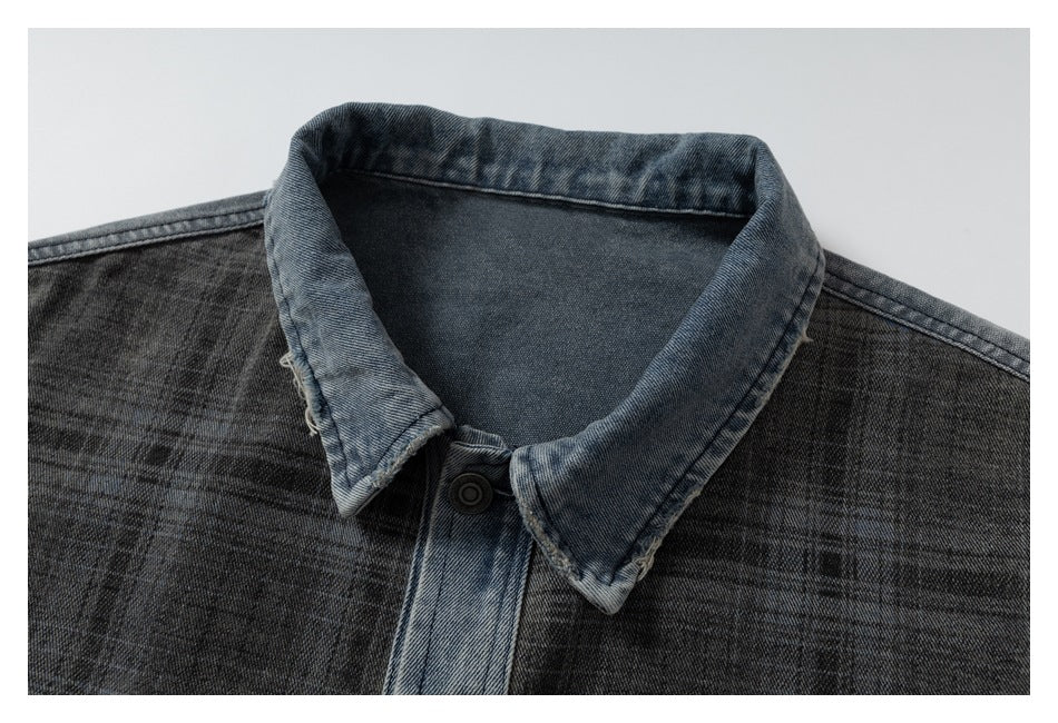 Close-up of the jacket’s pointed light blue denim collar, dark plaid fabric, and front button.
