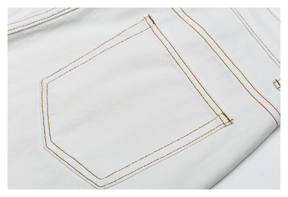 Close-up of a white denim back pocket with brown contrast stitching.